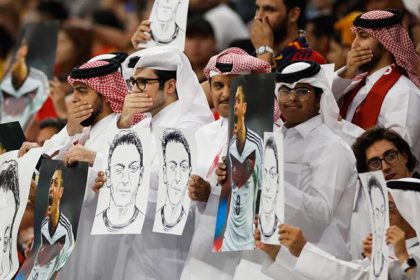 Potret fans Qatar membawa foto dan sketsa Mesut Ozil (Foto: REUTERS/John Sibley)